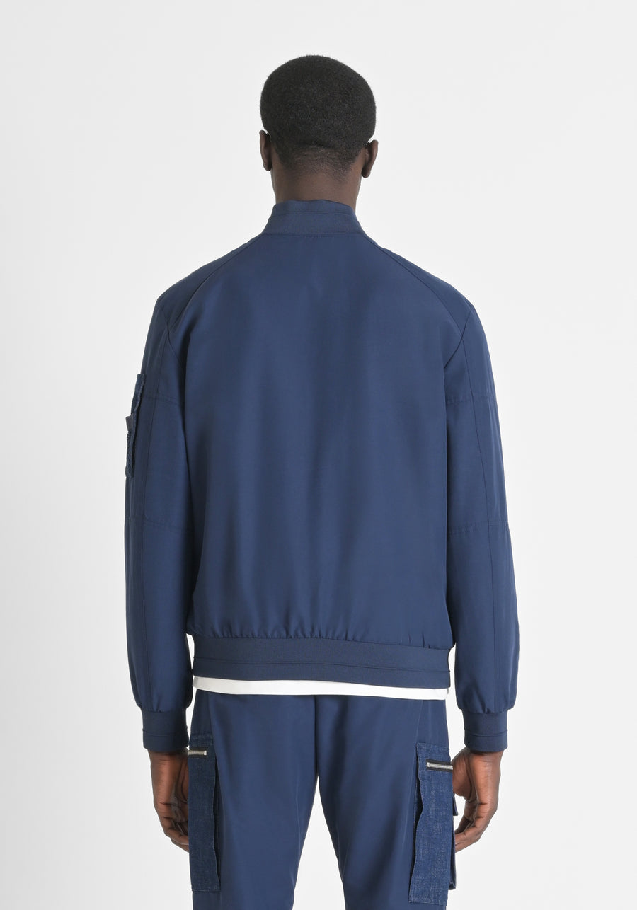 CHAQUETA EN TEJIDO IMPERMEABLE CON LOGOTIPO BORDADO EN EL PECHO